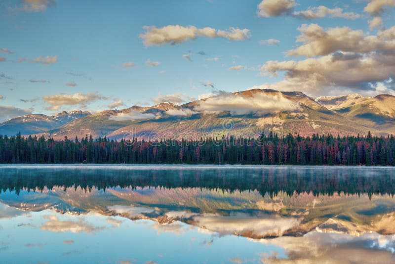 Morning sunrise in the Rocky Mountains at Annette Lake in Jasper National Park with reflections of Majestic Mountain and Aquila Mountain on the calm waters. Morning sunrise in the Rocky Mountains at Annette Lake in Jasper National Park with reflections of Majestic Mountain and Aquila Mountain on the calm waters