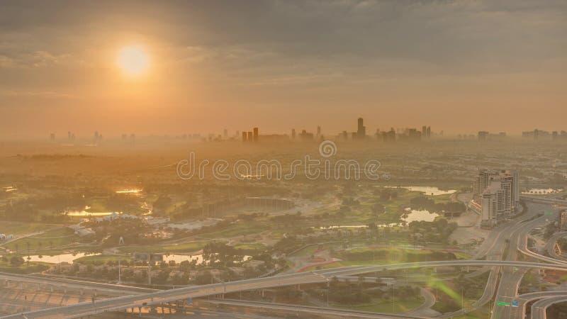 Sunrise over Golf course green lawn and lakes, villa houses behind it aerial . Village triangle and circle district. Top morning view from Dubai marina skyscraper. Sunrise over Golf course green lawn and lakes, villa houses behind it aerial . Village triangle and circle district. Top morning view from Dubai marina skyscraper.