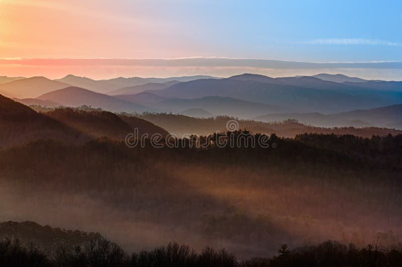 Sun rising over snowy mountains of Smokies in early spring with fog in valleys. Sun rising over snowy mountains of Smokies in early spring with fog in valleys