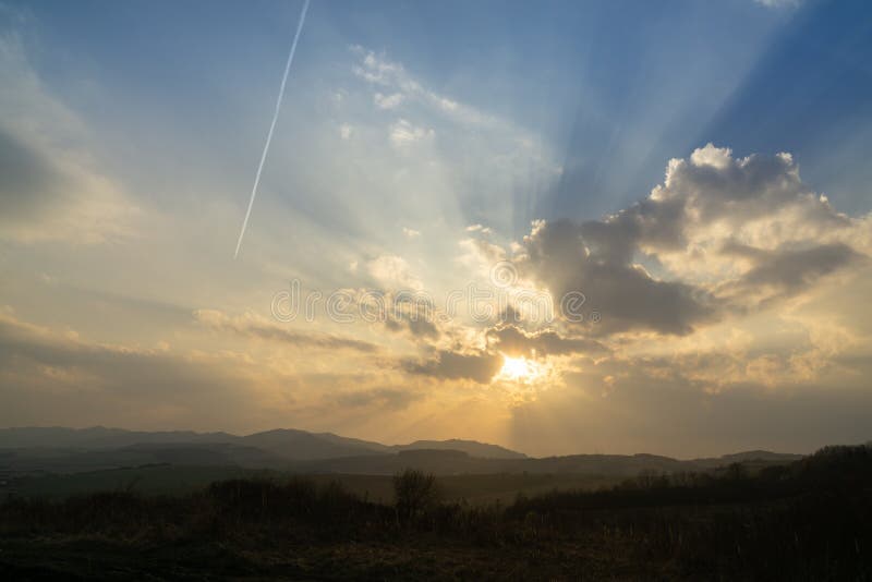 Sunrise or sunset over the hills and meadow.