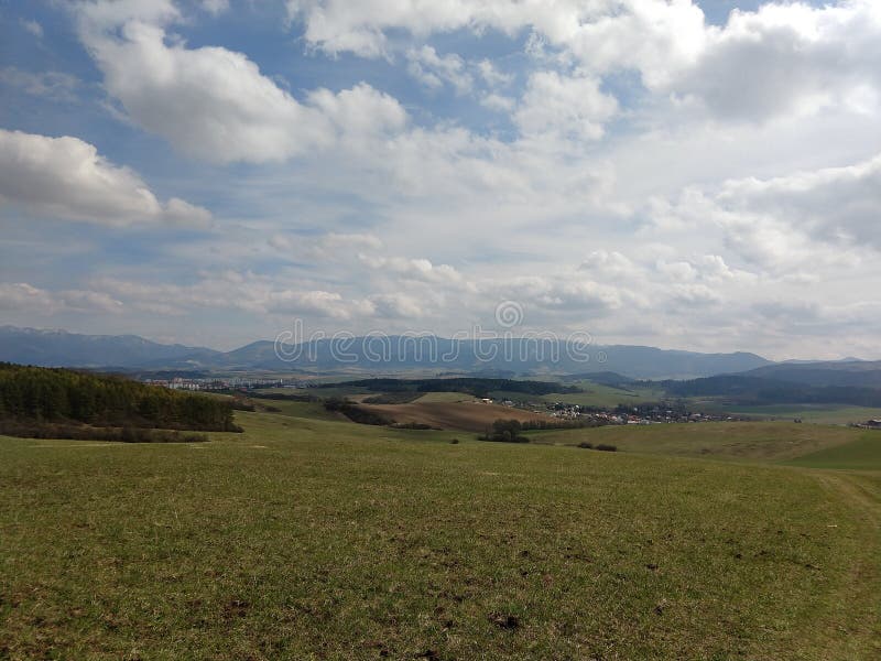 Východ alebo západ slnka nad kopcami a lúkou.