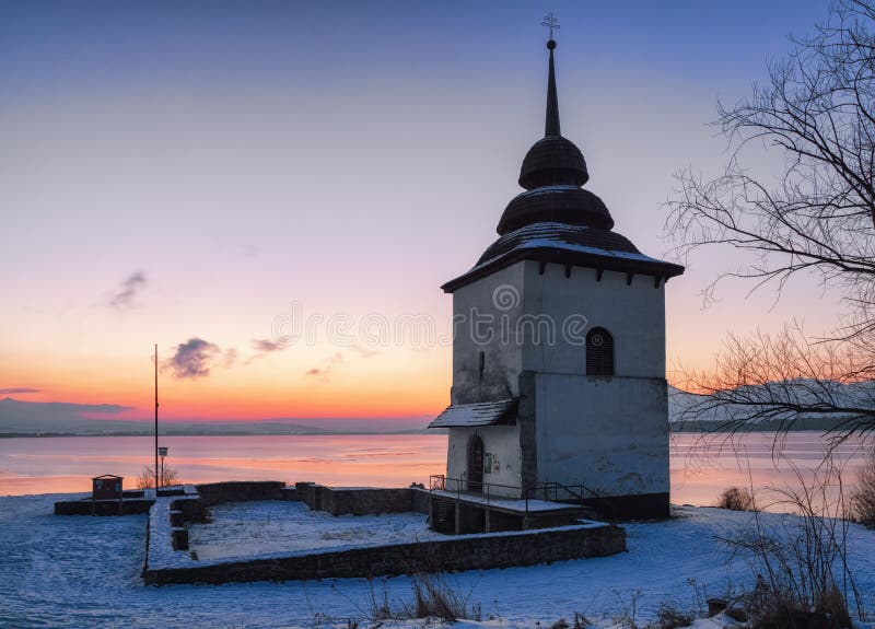 Sunrise and tower of church at reservoir Liptovska Mara, Slovak