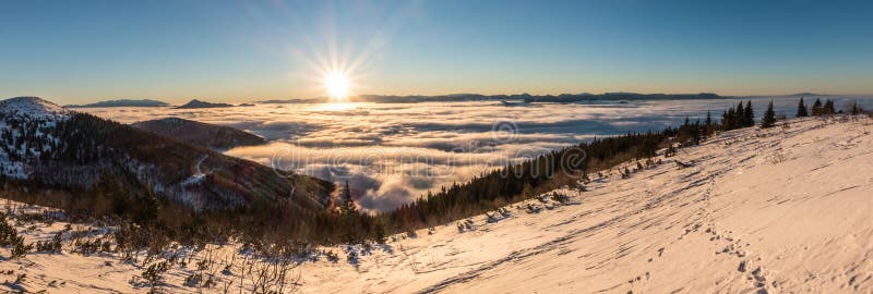 Sunrise at winter mountain ridge above clouds