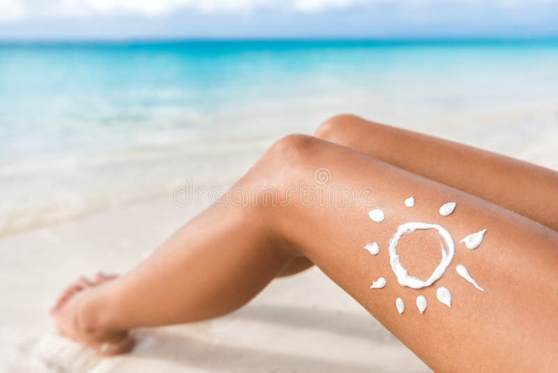 Sunscreen lotion sun drawing on beach suntan legs