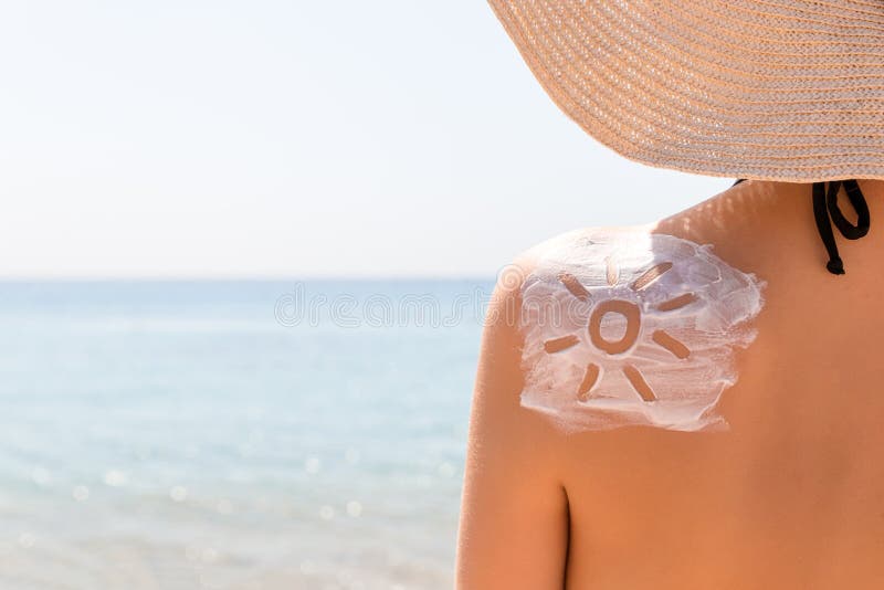 Sunscreen λοσιόν στη μορφή ήλιων στο μαυρισμένο ώμο της γυναίκας στοκ φωτογραφία με δικαίωμα ελεύθερης χρήσης Sunscreen λοσιόν στη μορφή ήλιων στο μαυρισμένο ώμο της γυναίκας στοκ φωτογραφία με δικαίωμα ελεύθερης χρήσης