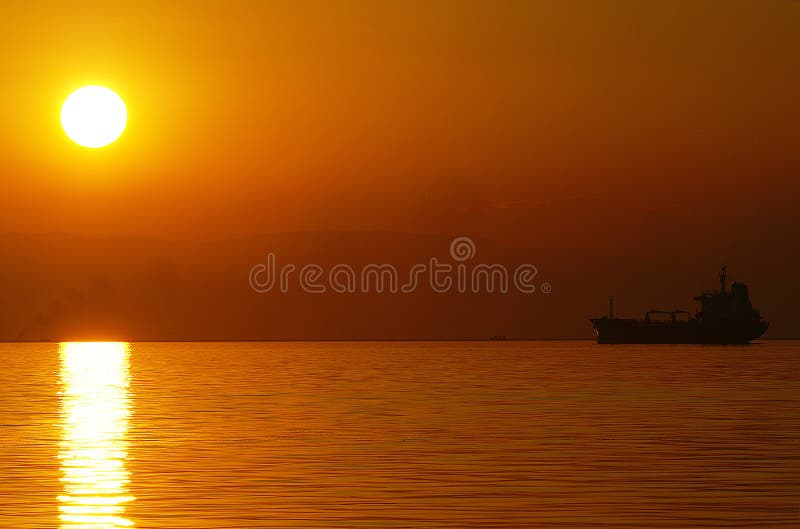 Sonnenuntergang mit einem Schiff am Horizont.