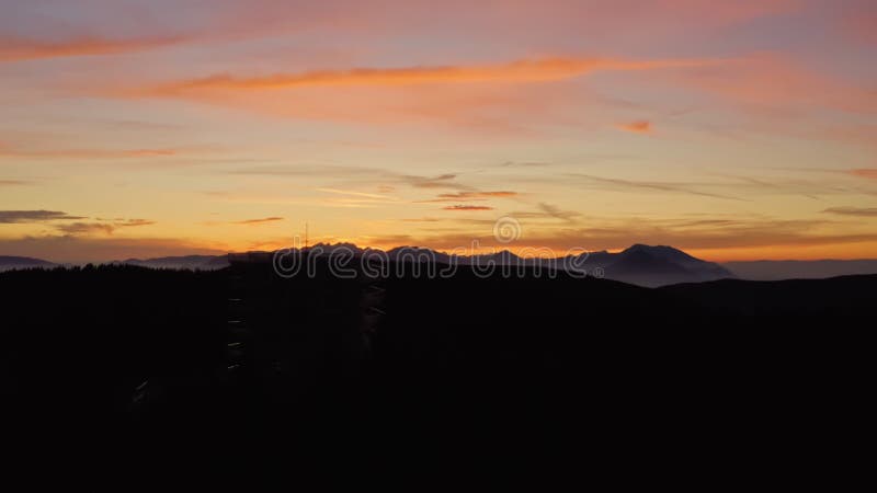 Sunset above mountains and lookout tower in front