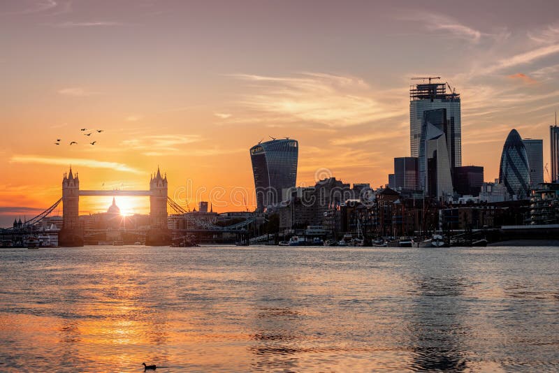 Sunset behind the skyline of London, UK, during: from the Tower Bridge to the modern skyscrapers of the City