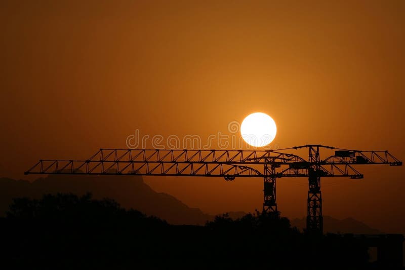 Sunset behind steel cranes