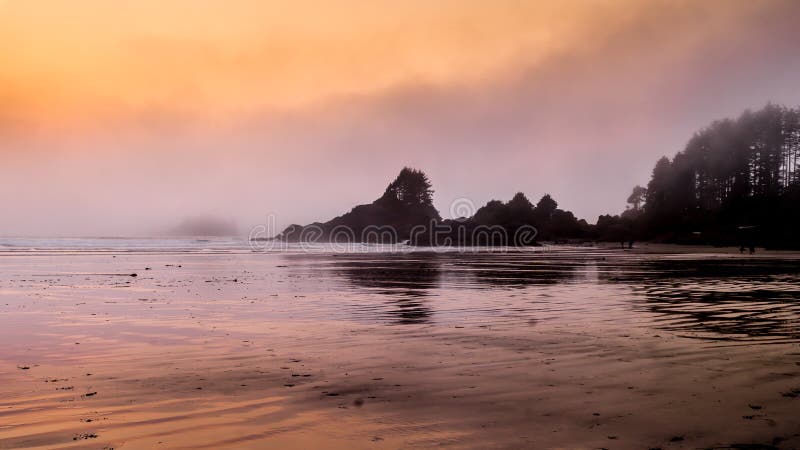 Sunset causing an Orange Glow over the Fog hanging over the rocky shore between Cox Bay and Chesterman Beach