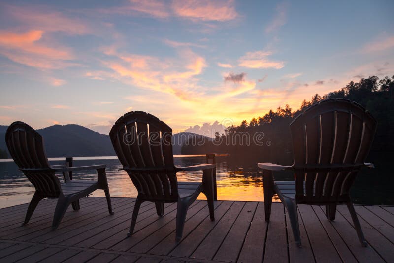 Adirondack Chairs on a Dock on a Lake at sunset