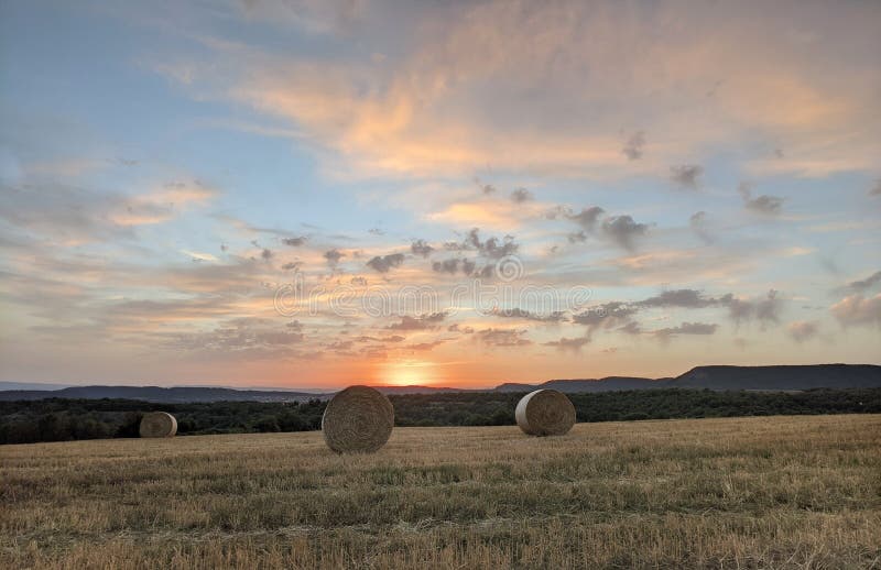 Sunset cloudscape over harvested field stock photos