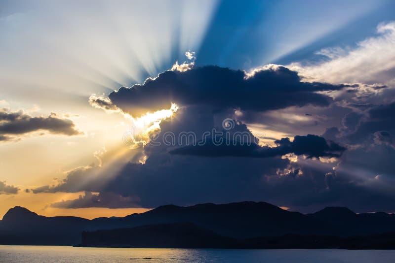 Sunset In The Cloudy Sky By The Sea Over The Mountains Stock Photo