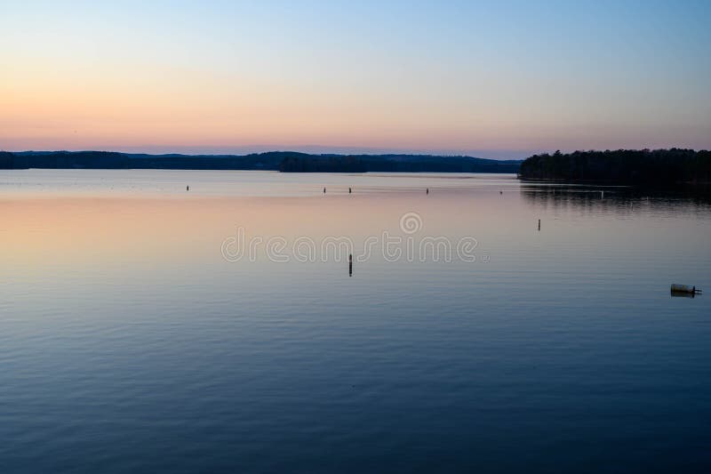 Buoys sticking up in the lake at sunset