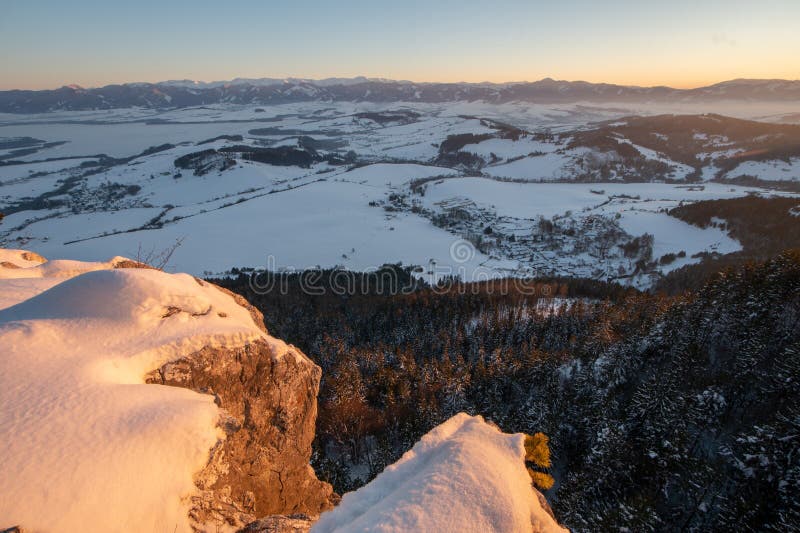 Sunset from Janosikov stol rock over Liptovska Anna village in Chocske vrchy mountains during winter