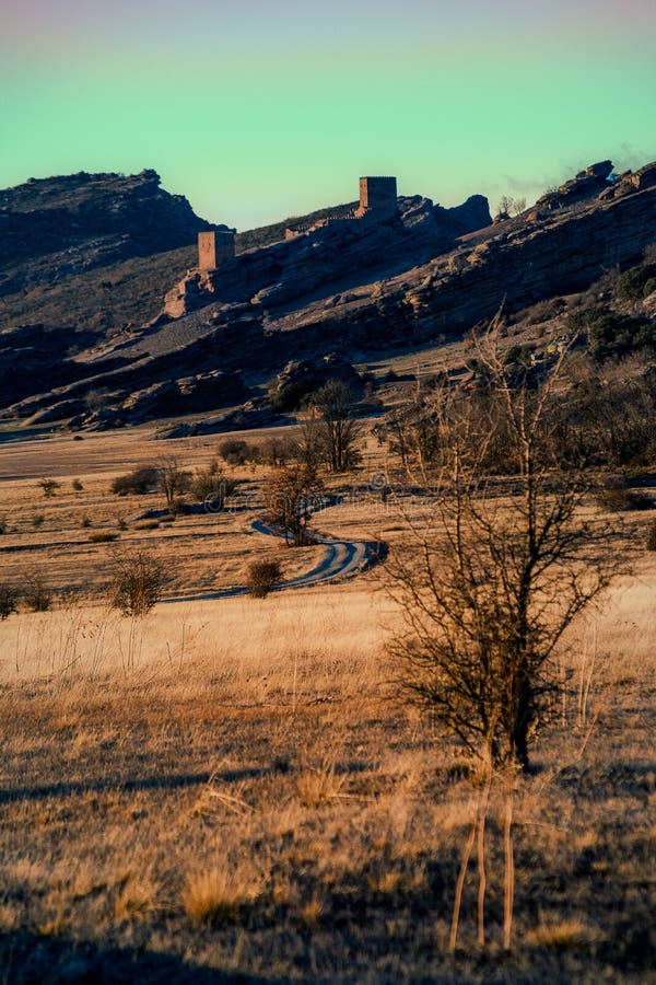 Sunset landscape with some mountains and a castle o