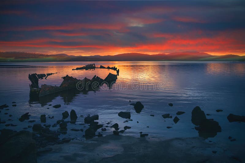 Stunning, vibrant sunset over beach and shipwreck
