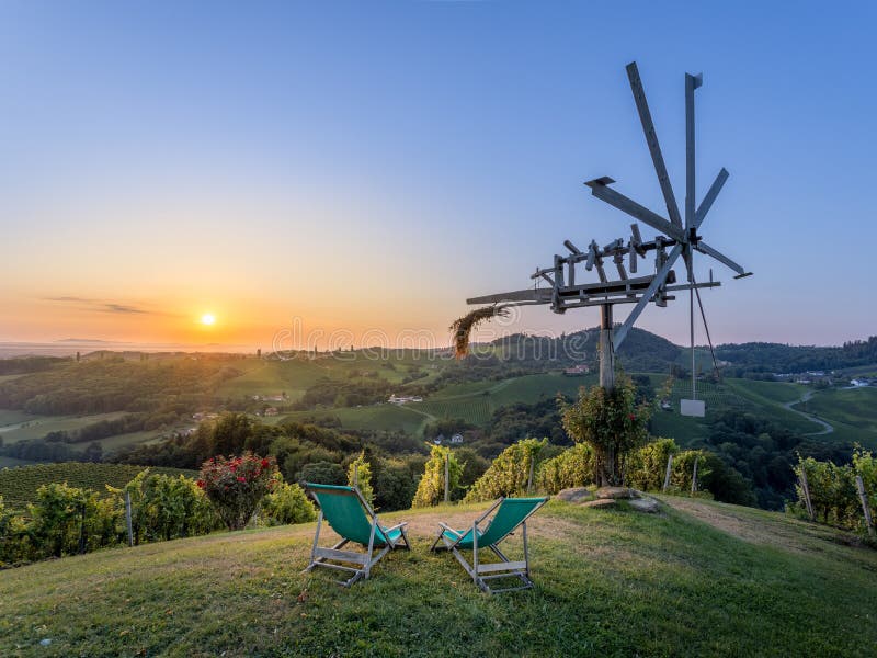 Sunset over de druppels in Eckberg, bekeken vanuit Sernauberg - 2 deckstoelen tussen de wijngaard en een Klapotetz - bij Gamlitz stock foto's Sunset over de druppels in Eckberg, bekeken vanuit Sernauberg - 2 deckstoelen tussen de wijngaard en een Klapotetz - bij Gamlitz stock foto's