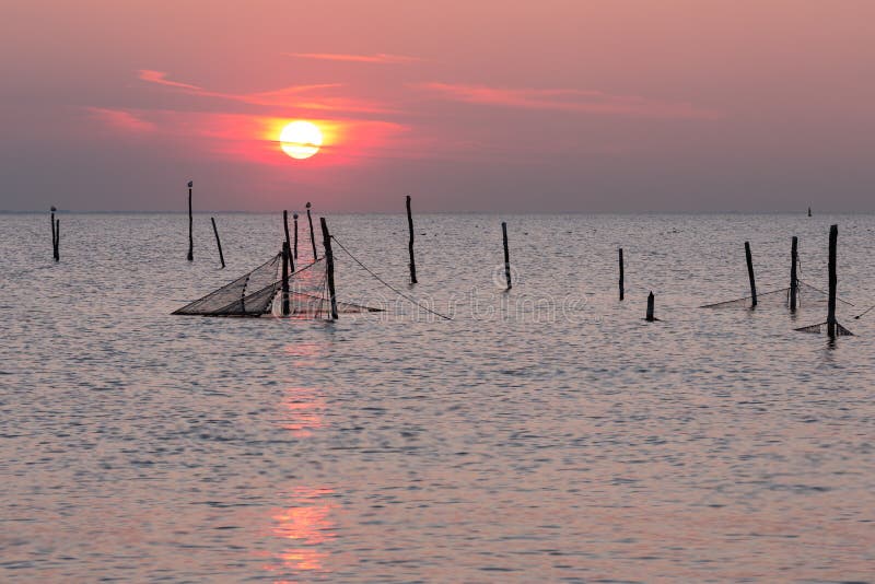 Sunset over Dutch sea with fishing nets