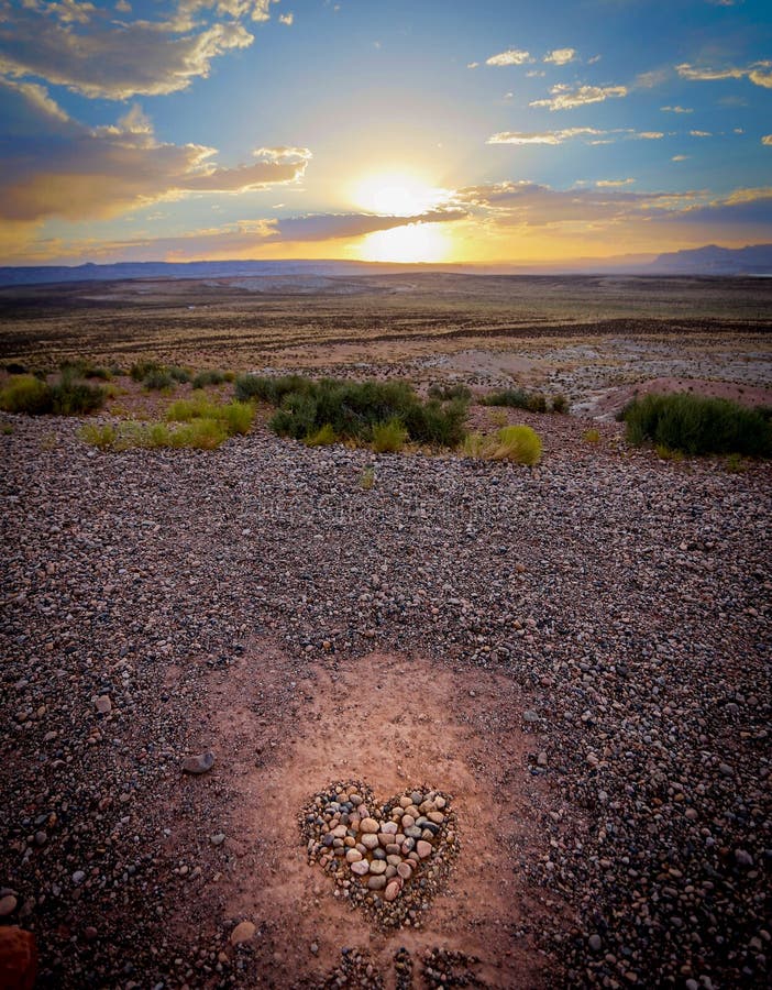 Sunset over a heart made of pebbles stock photography