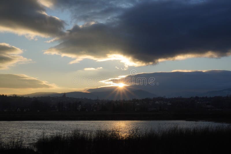 sunset over the mountains Beskids Slaski in Zywiec, Poland and clouds on the other side of the river or lake. bright clouds