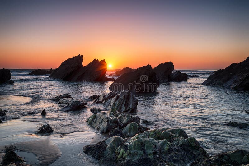 Sunset over rocks on Sharrow beach