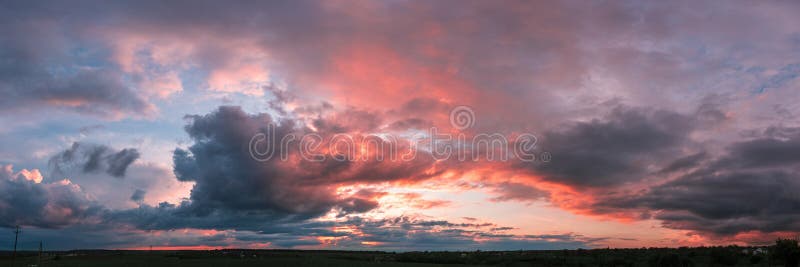 Sunset panorama with raspberry clouds over a small town stock images
