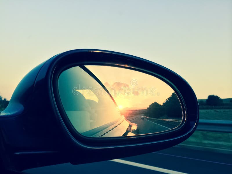 Sunset in a rear view mirror royalty free stock photography