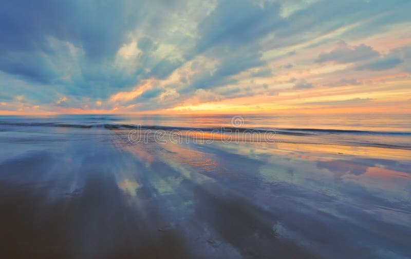 Sunset with reflection on sand with slight zoom blura