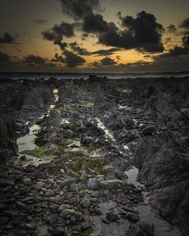 Sunset scene on beautiful rocky beach in Freshwater West on Pembrokeshire coast,South Wales, UK royalty free stock photos Sunset scene on beautiful rocky beach in Freshwater West on Pembrokeshire coast,South Wales, UK royalty free stock photos