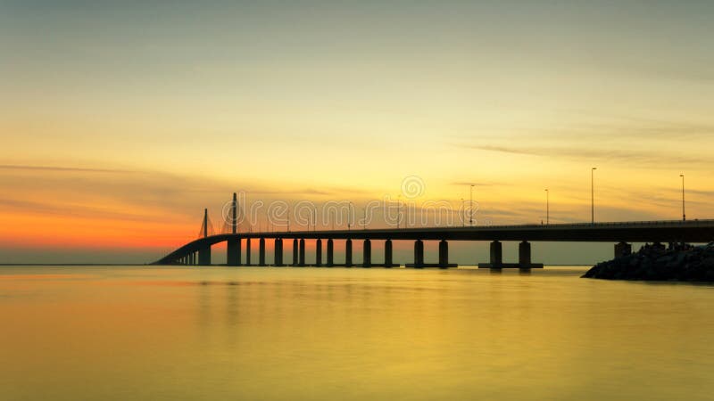 Sunset at the sea with bridge over the peaceful water panorama