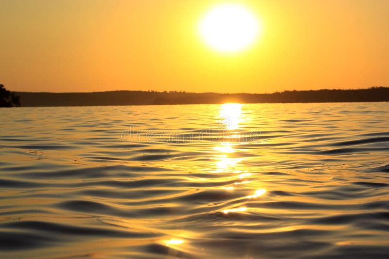 Sunset, sea waves close up, low-angle of view. Water surface. River, lake, pond. stock photography