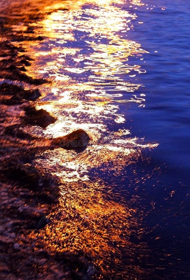 Zlatý západ slnka na pláži na pobreží, ktoré sa vzťahuje na more burín na Mission bay park, San Diego, California.