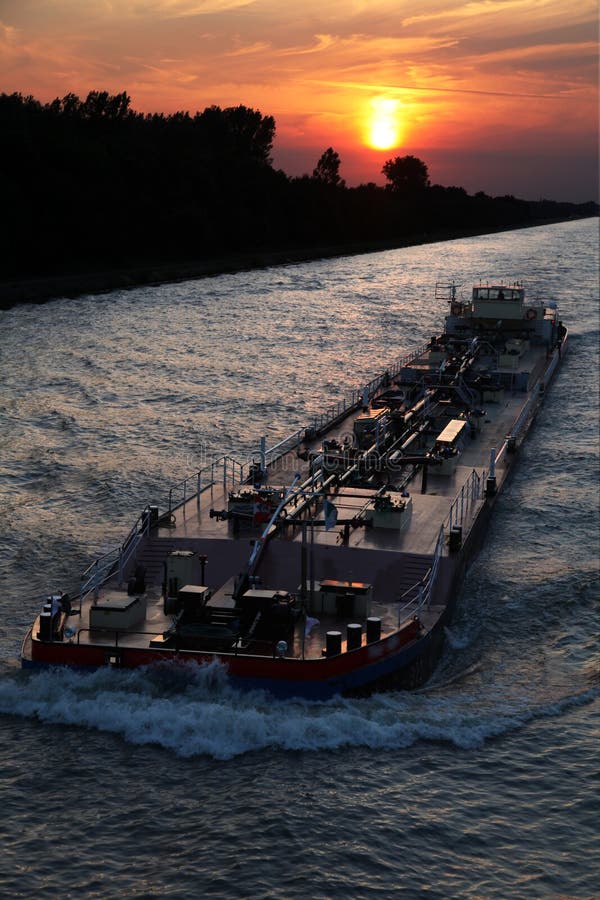 Sunset ship. Ship moving on the water during sunset Sunset ship. Ship moving on the water during sunset