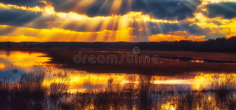 Západ slunce s paprsky světla venkova scénický výhled v oblastech s vodou, Litva.