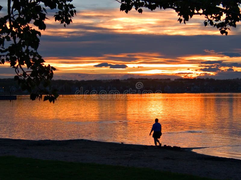 Solitario una mujer camina costas de, sobre el atardecer.