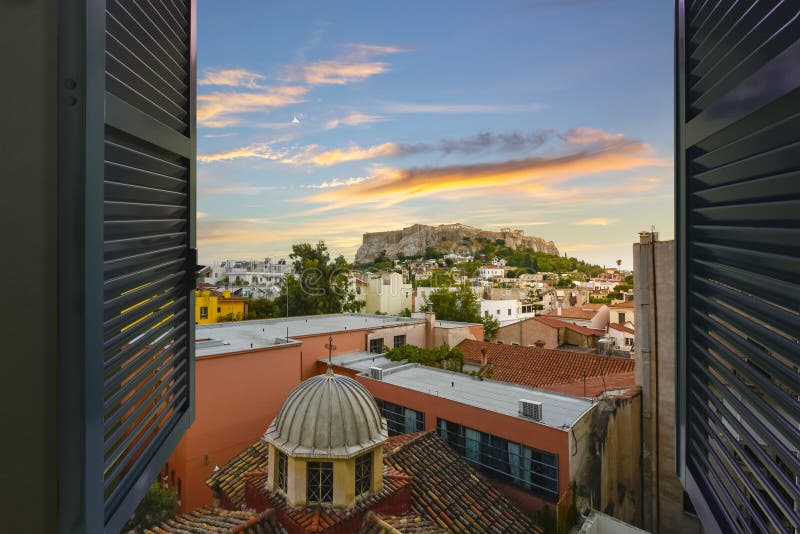 Sunset view of the ancient Parthenon and Acropolis Hill through an open window overlooking the Plaka district of Athens, Greece stock images Sunset view of the ancient Parthenon and Acropolis Hill through an open window overlooking the Plaka district of Athens, Greece stock images