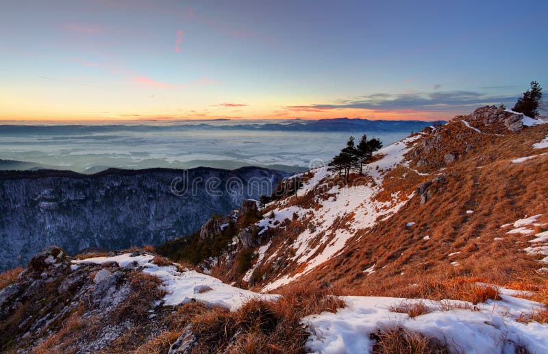 Sunset in winter mountains landscape with forest