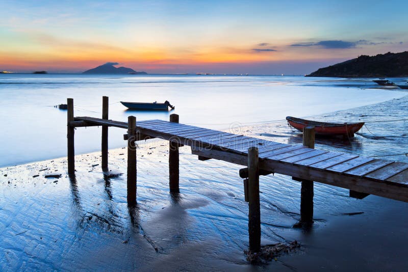 Sunset at wooden pier along the coast