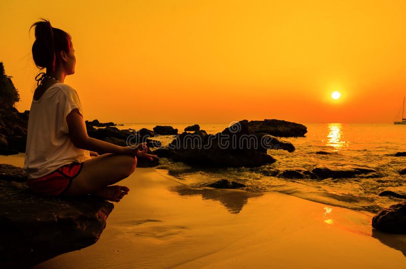Sunset yoga woman with spirituality on sea coast