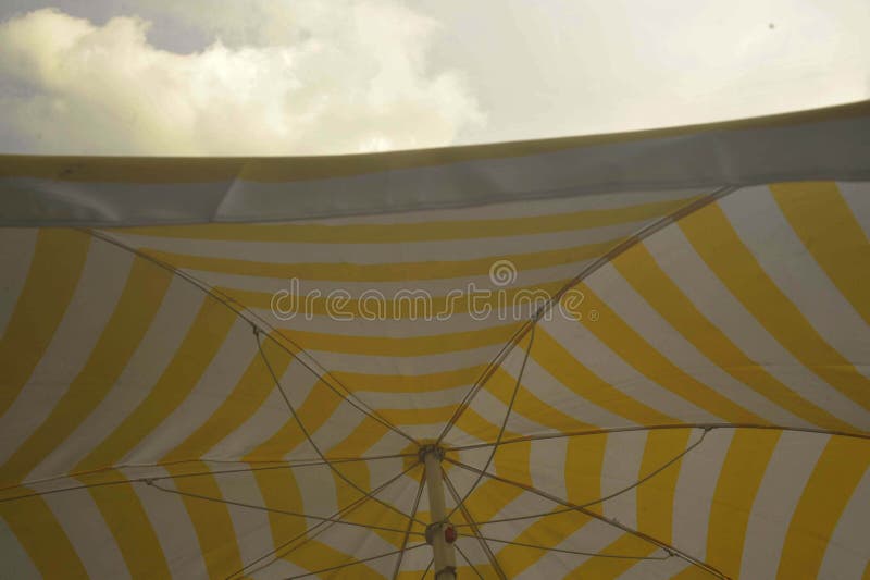 Sunshade as protection against sunburn. Yellow and blue striped sunshades as protection against a sunburn stock photography Sunshade as protection against sunburn. Yellow and blue striped sunshades as protection against a sunburn stock photography