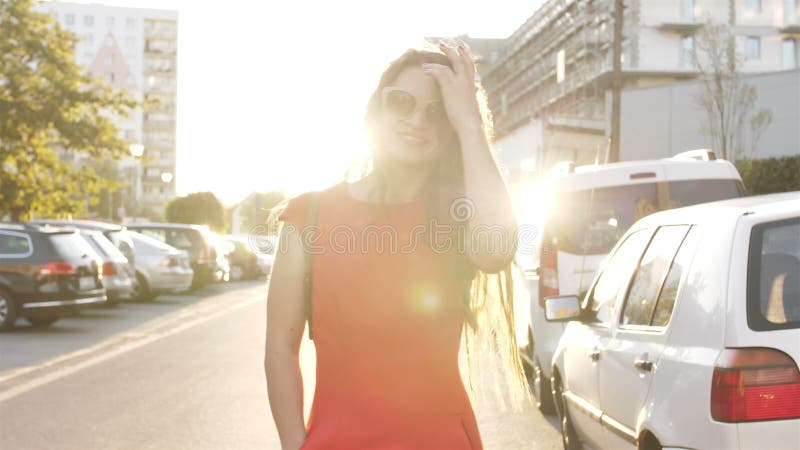 Sunshine, giovane donna sorridente con i capelli ricci, guarda il sorriso sulle telecamere mentre cammina per le strade della cit