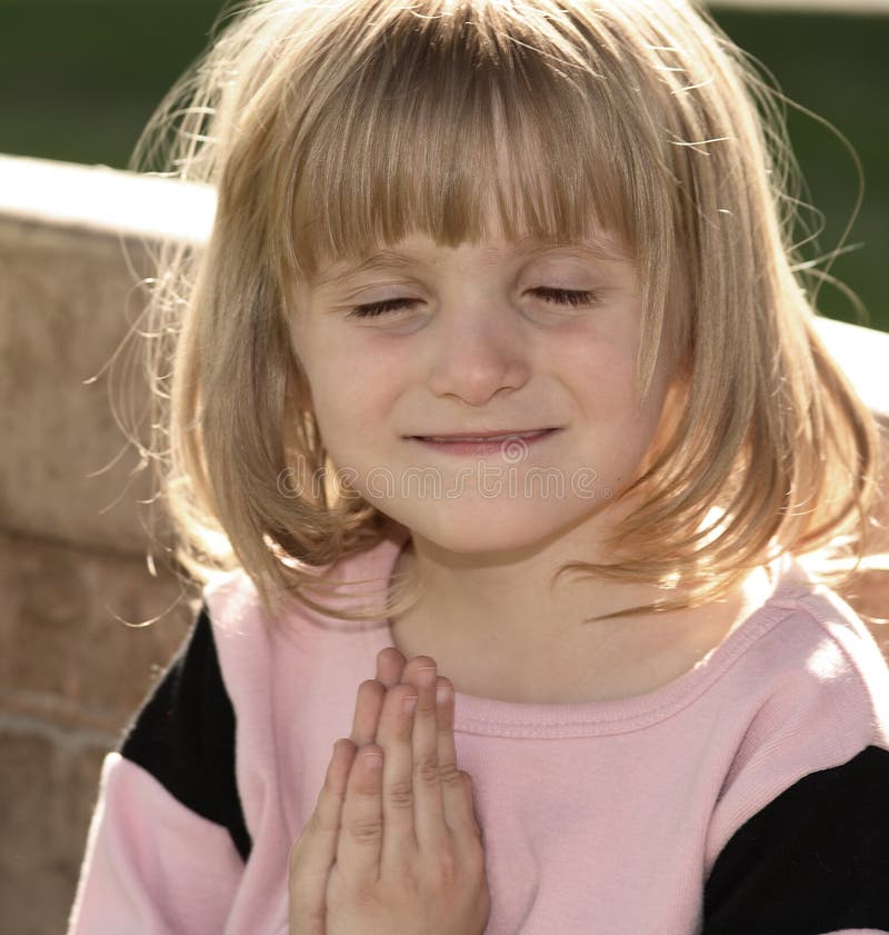 Little girl praying outside on a park bench. Little girl praying outside on a park bench