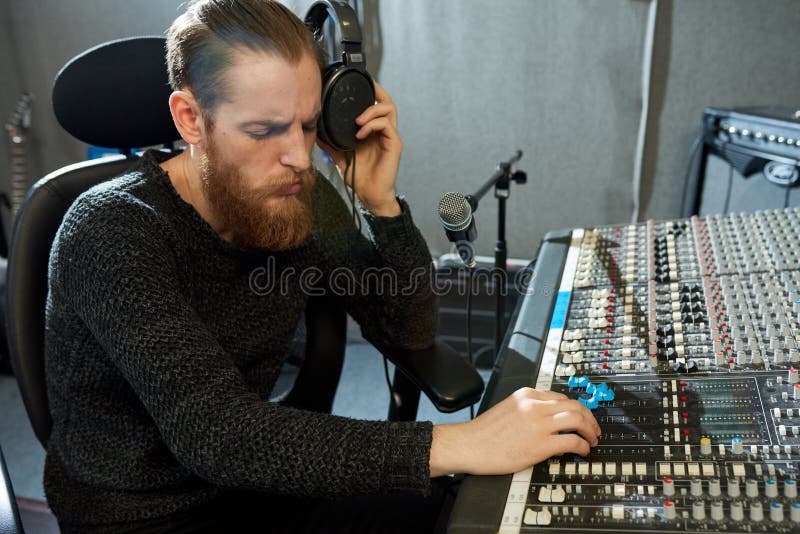 Suoni di regolamento concentrati del progettista di musica in studio fotografia stock Suoni di regolamento concentrati del progettista di musica in studio fotografia stock