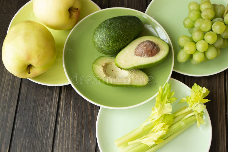Super food selection for health diet, fresh green and yellow vegetables and fruits on green gradient plates, vintage wooden stock image Super food selection for health diet, fresh green and yellow vegetables and fruits on green gradient plates, vintage wooden stock image