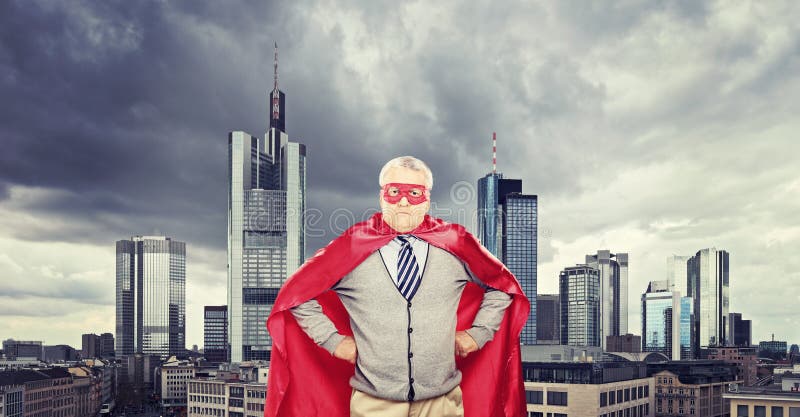 Super-herói maduro orgulhoso que está na frente de uma cidade foto de stock royalty free