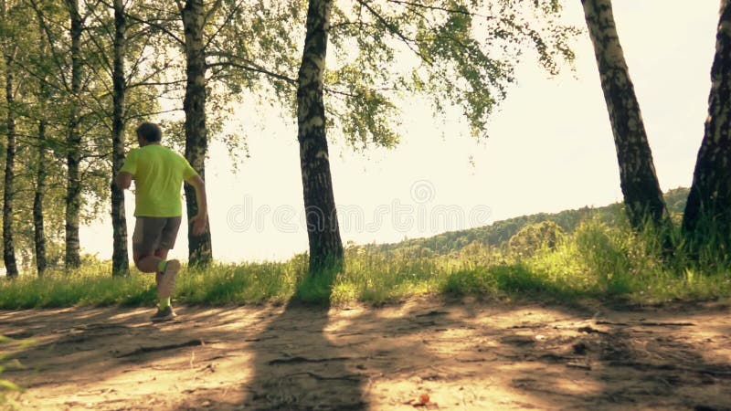 Sportsman running along the park alley