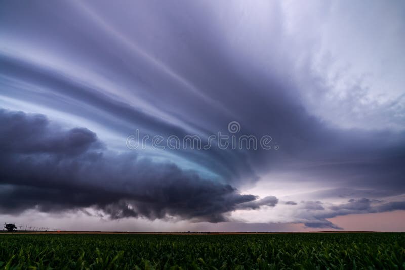 Supercell thunderstorm and stormy night sky with dramatic clouds over a field during a severe weather outbreak. Supercell thunderstorm and stormy night sky with dramatic clouds over a field during a severe weather outbreak.