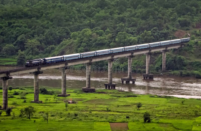Superfast Janshatabdi train express sort un tunnel coupé à travers la colline et voyage au-dessus d'un long pont à Sangameshwar Ma photo libre de droits