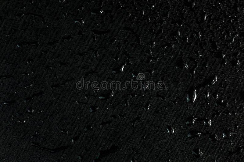 Superficie de goma plana negra con agua cae fondo macro oscuro